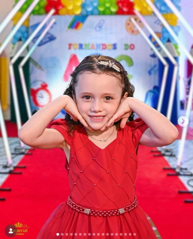 Niña en vestido rojo en alfombra roja